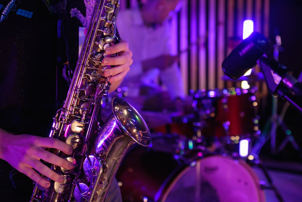 Musicians playing saxophone and drums during a vibrant live performance.
